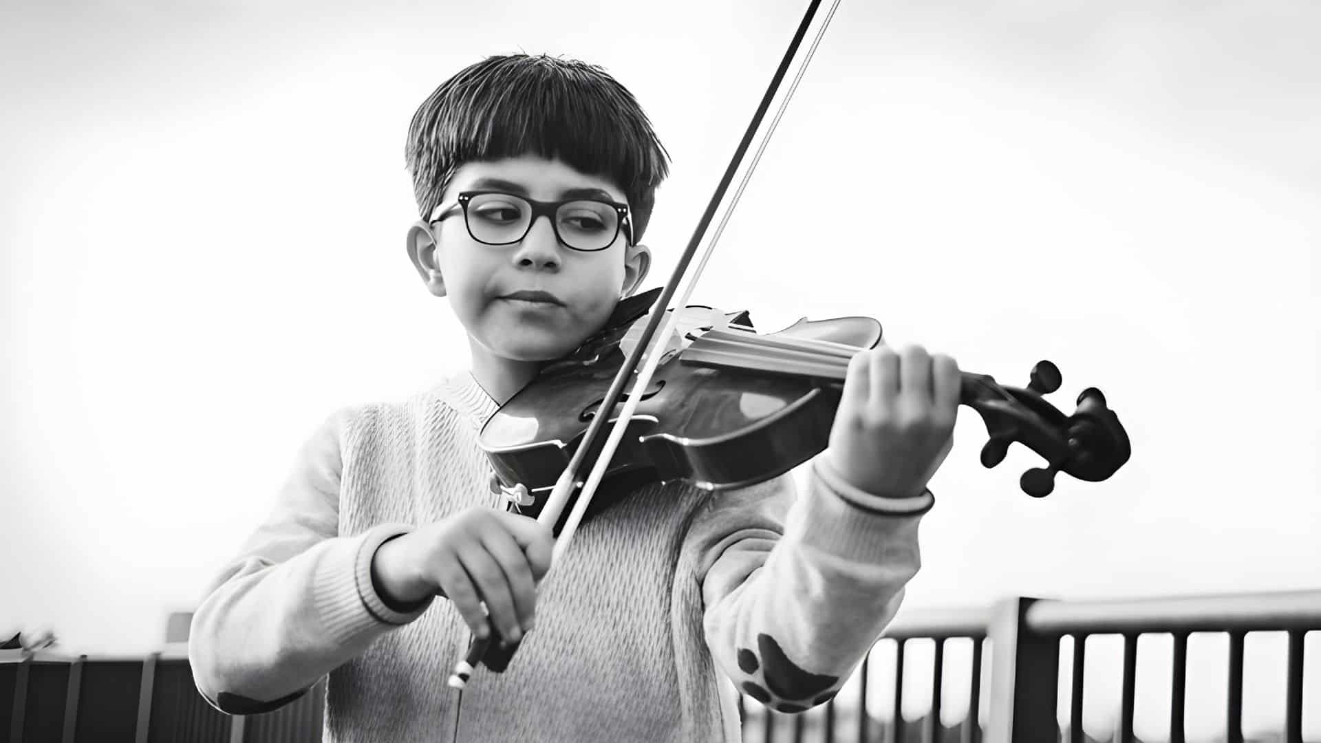 Beginning violin student practicing with focused attention